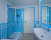 a blue tiled shower and sink